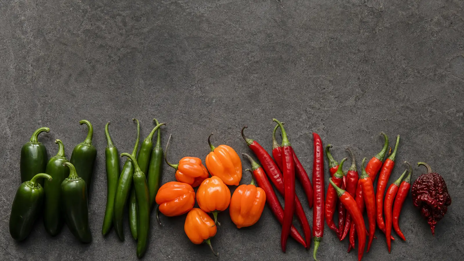 A spread of fresh chili peppers across the heat spectrum